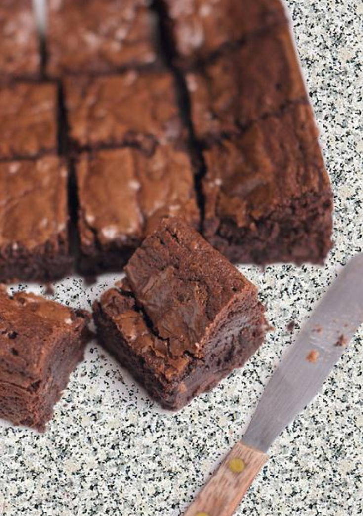 Sliced Nigel Slater chocolate brownies with crackly tops and fudgy centres on a speckled worktop beside a knife